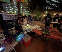 a group of people standing around a table with electronic equipment
