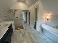 a white bathroom with a tub and sink