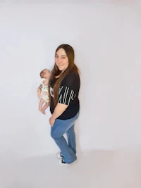a woman holding a baby in front of a white background