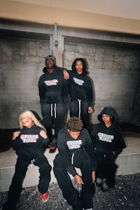 a group of people posing for a photo in a black hoodie