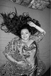 a black and white photo of a woman laying on a bed