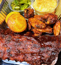 a tray of ribs, broccoli, and mashed potatoes