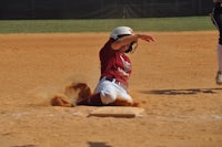 a softball player sliding into base during a game