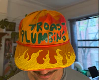 a man wearing a hat that says toast plumbing