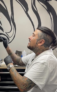 a man getting tattooed by a tattoo artist