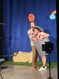 a group of people on stage with a camera in front of them