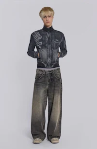 a man in a denim jacket and wide leg pants