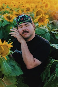 a man with a mustache in a field of sunflowers