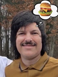 a man with a burger in his mouth and a thought bubble over his head