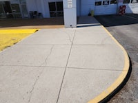 a parking lot with a yellow curb and a yellow sign