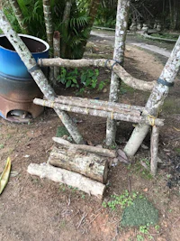 a bench made out of logs on the ground