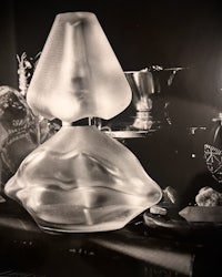 a black and white photo of a glass lamp