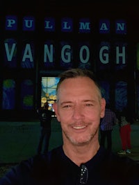 a man taking a selfie in front of a building that says pullman vangogh