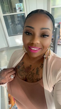 a woman wearing a brown top and pink tattoos