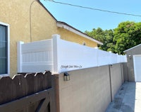 a white fence next to a house