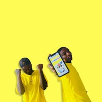 two men in yellow shirts holding up their phones