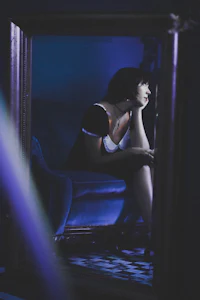 a woman sitting on a blue couch in front of a mirror