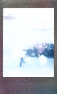 a polaroid photo of a person walking down the street