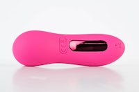 a pink vibrating toy on a white surface