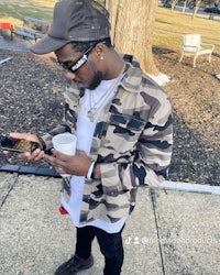 a man in a camouflage jacket looking at his phone