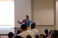a clown performs in front of a group of people