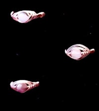 a set of four pink stone rings on a black background