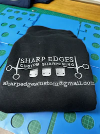 a black t - shirt with the words sharp edges on it