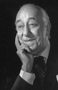 a black and white photo of an older man with his hand on his chin