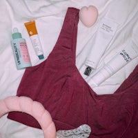 a pink bra top laying on a bed with other items