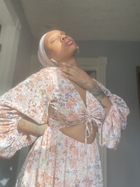 a woman in a floral dress posing in a room