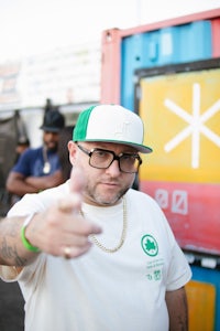 a man wearing a hat and a t-shirt giving the thumbs up