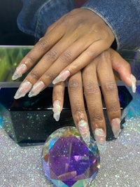a woman's hand holding a crystal and a diamond