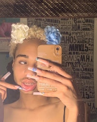 a woman taking a selfie with her nails in a flower crown