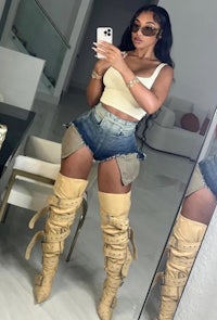 a woman taking a selfie in thigh high boots