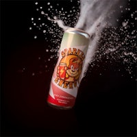 a can of soda is being splashed with water