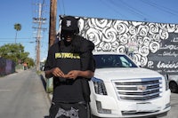 a man in a black hat is standing next to a white van