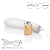 a white and gold vibrator with a charger attached to it