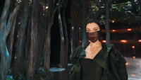 a woman wearing a mask in a forest
