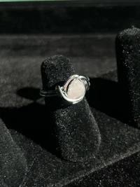 a silver ring with a pink stone in it