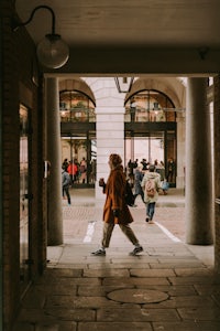 a woman is walking down an alleyway