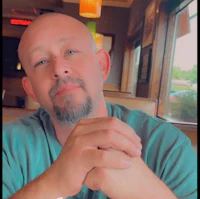 a bald man sitting at a table in a restaurant