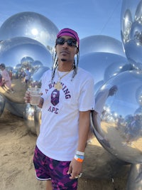 a man standing in front of a group of silver balls