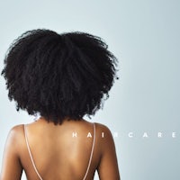 the back of a woman with afro hair and the words haircare