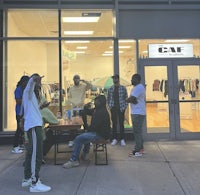 a group of people standing in front of a clothing store