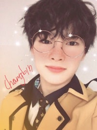 a young man wearing glasses and a tie