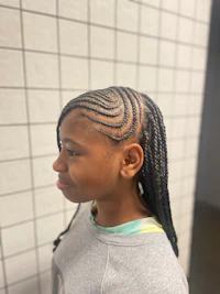 a young girl with braided hair in a bathroom