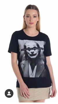 a woman wearing a black t - shirt with an image of the joker