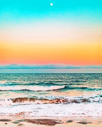 a colorful sunset over the ocean and waves