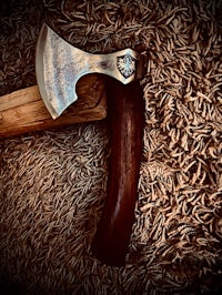 a wooden axe is laying on top of a pile of grain