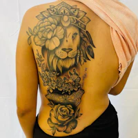 a woman with a tattoo of a lion and roses on her back